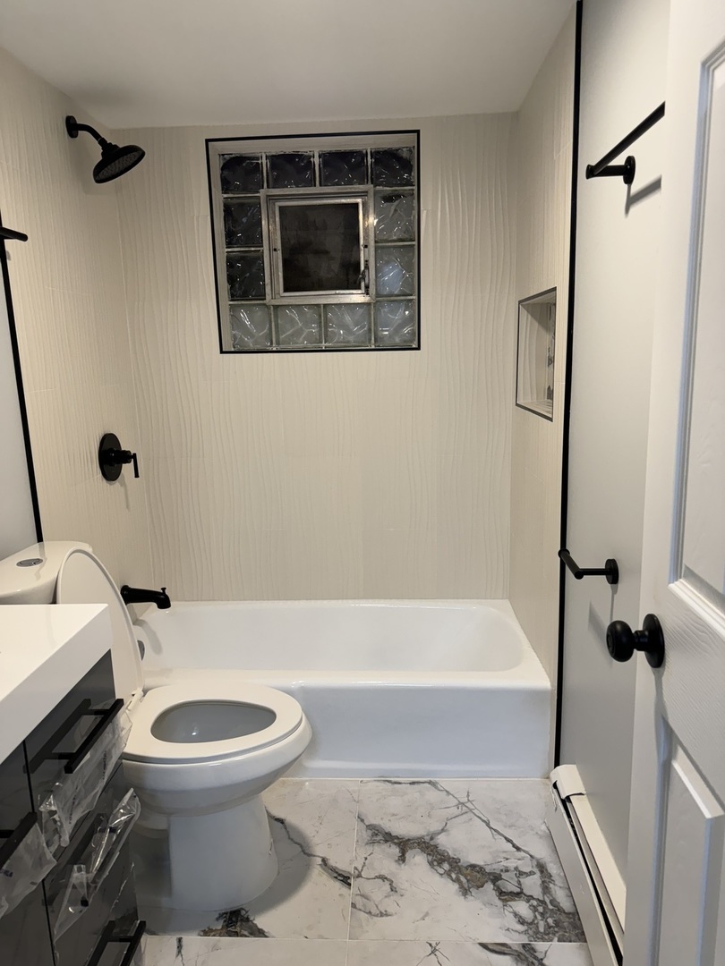 82 Luella Avenue, Unit 2 Calumet City, IL 60409 - Photo 9 of 12 a bathroom with a toilet a sink and bathtub