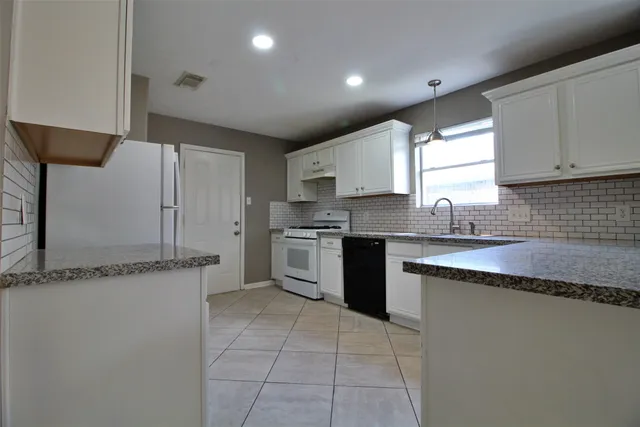 a kitchen with stainless steel appliances granite countertop a sink stove and cabinets