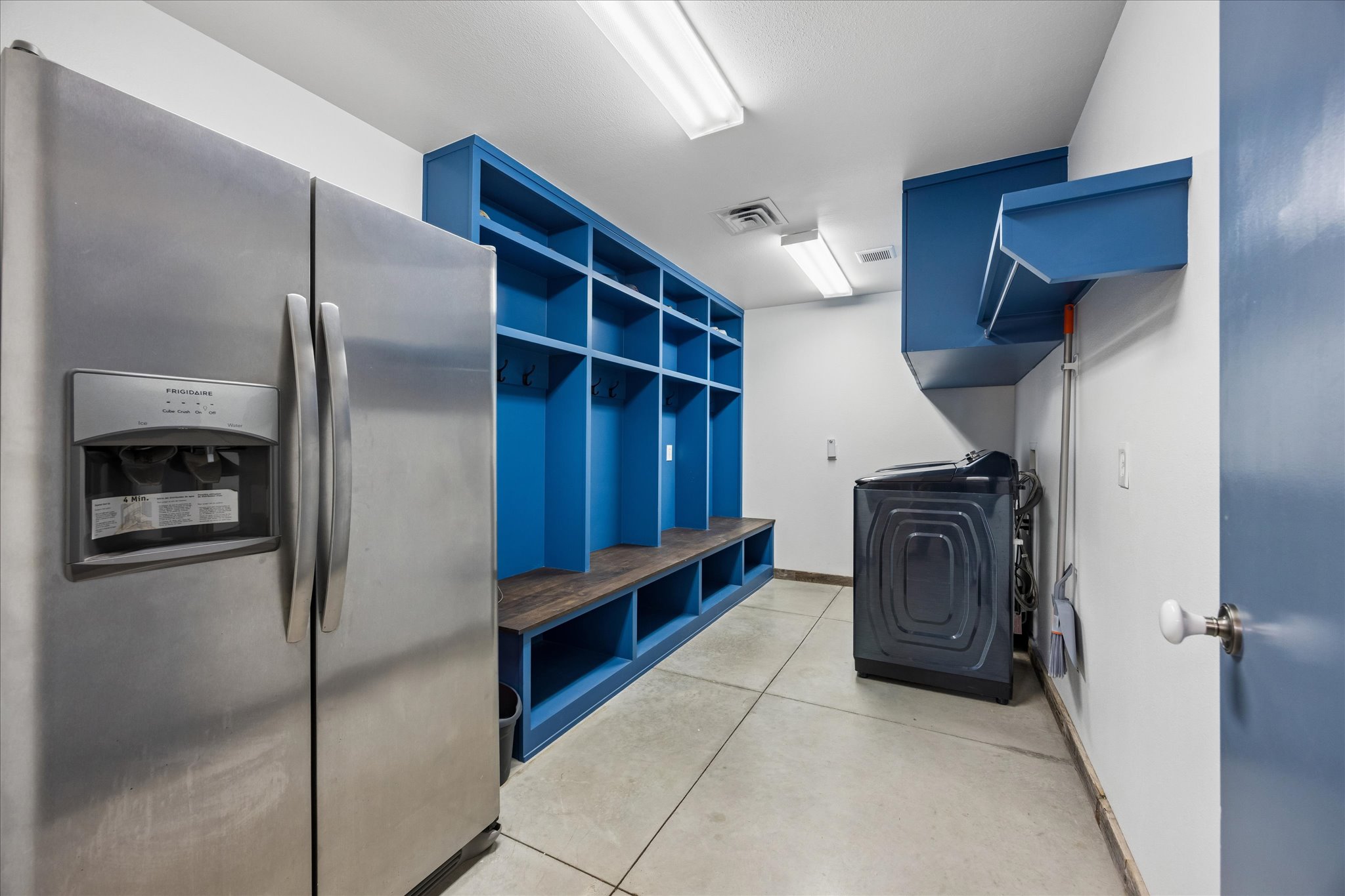 6411 West Fitzhugh Road Dripping Springs, TX 78620 - Photo 20 of 34 Utility space featuring blue built-in shelving, wood-finish bench seating, and concrete flooring