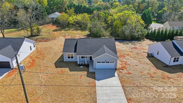 an aerial view of a house with swimming pool and large trees