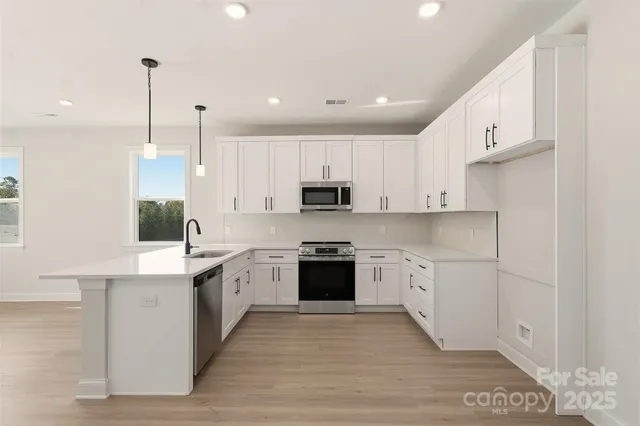 a large kitchen with cabinets and stainless steel appliances