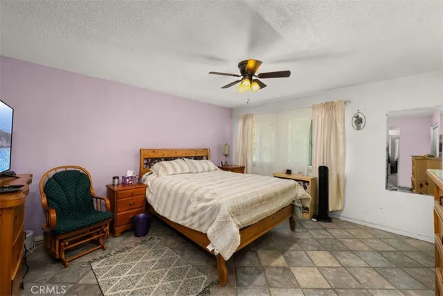 a bedroom with a bed a chandelier and a dresser