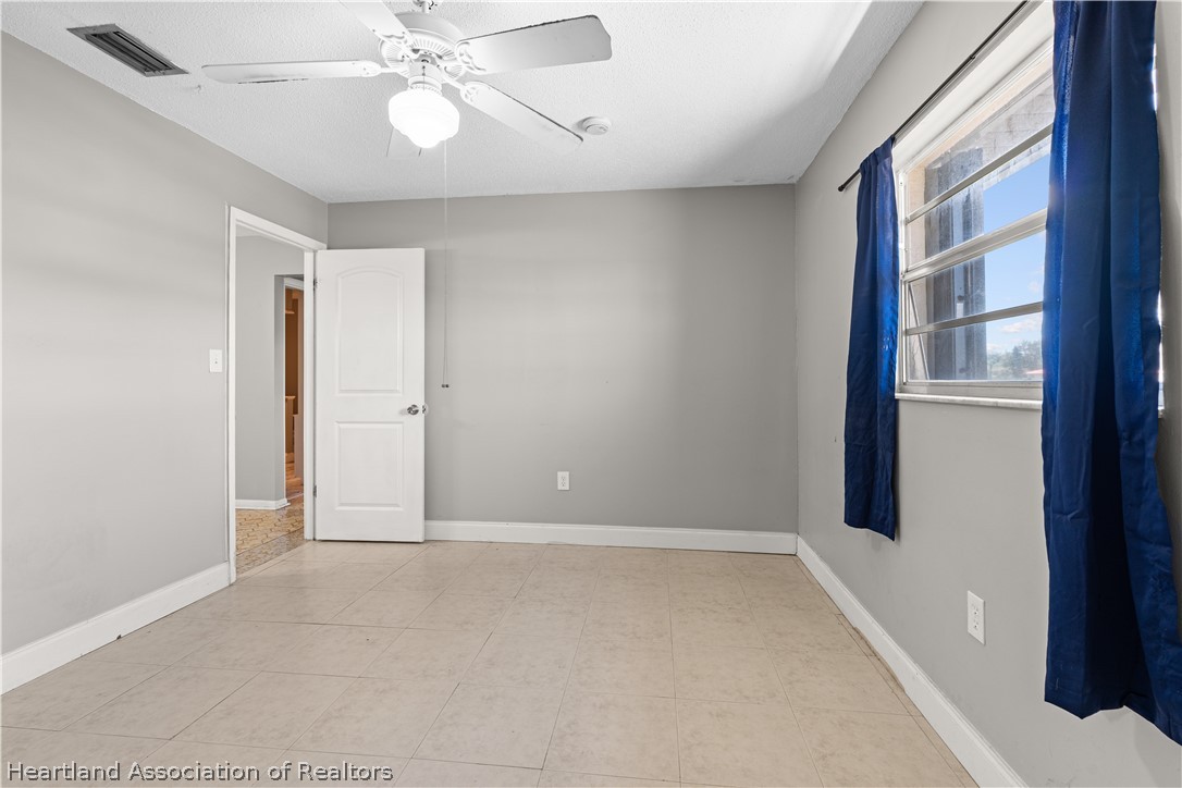 7100 Coral Ridge Road Sebring, FL 33876 - Photo 38 of 44 an empty room with chandelier fan and windows