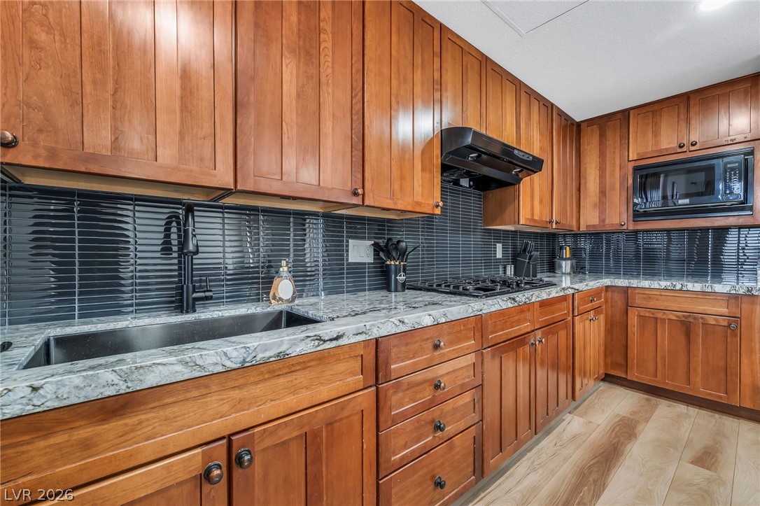 104 Appian Way Henderson, NV 89002 - Photo 11 of 24 A well-appointed culinary space featuring ample wooden cabinetry and durable countertop surfaces.