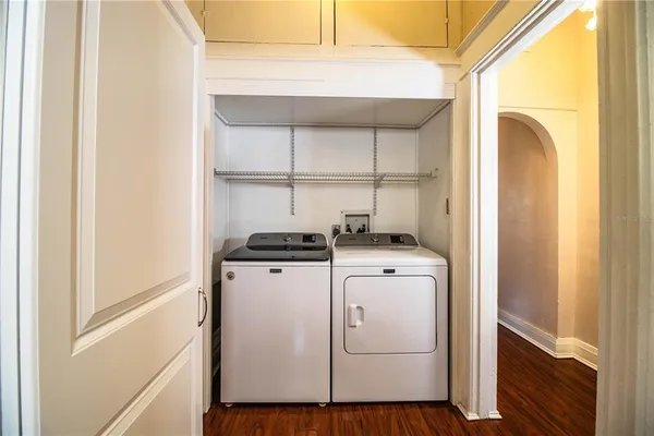 a kitchen with a refrigerator a stove a sink dishwasher and white cabinets with wooden floor