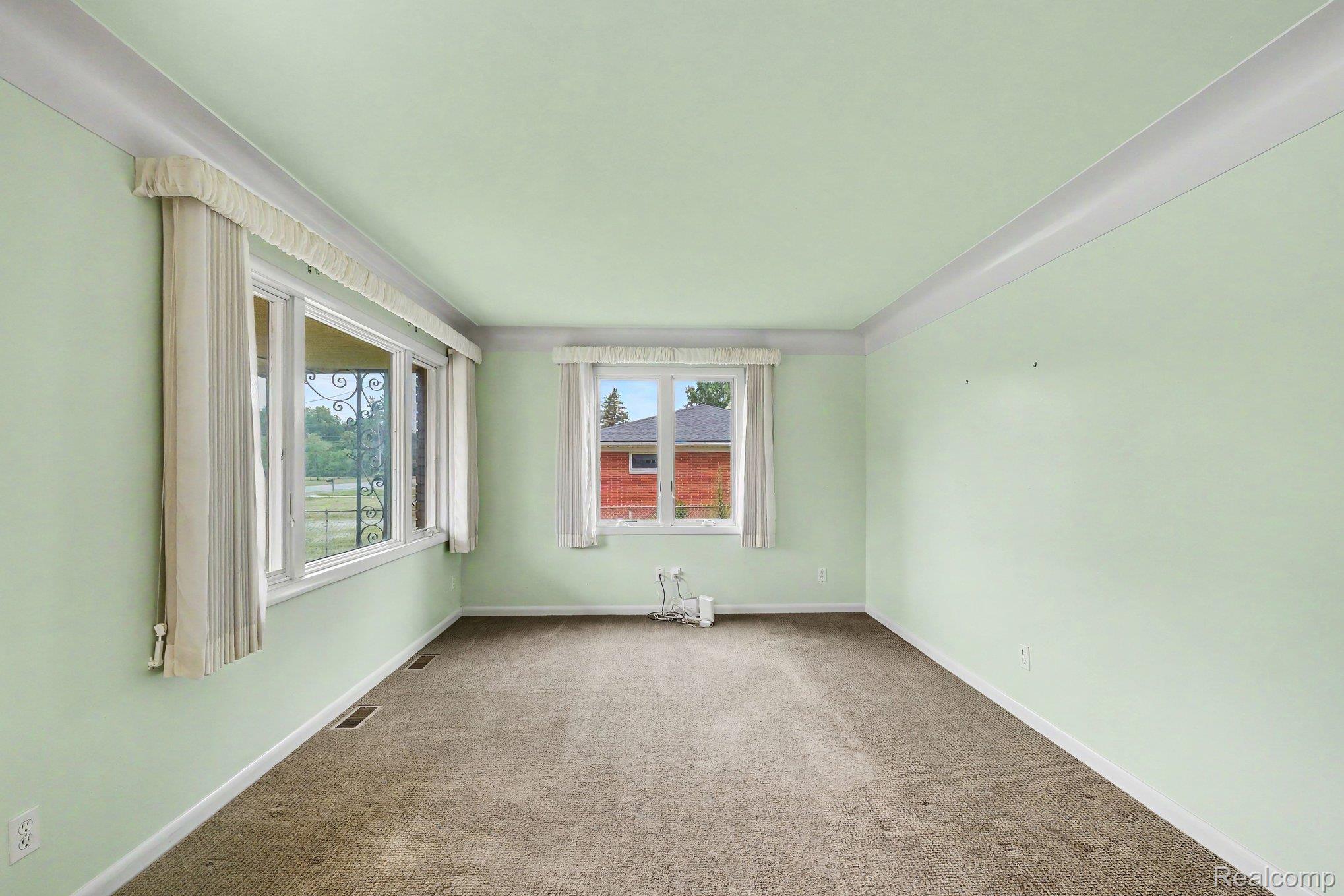 5199 Lapeer Road Burton, MI 48509 - Photo 6 of 19 Carpeted interior space featuring light green walls, white crown molding, and white baseboards