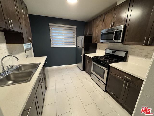 a kitchen with stainless steel appliances a refrigerator and sink