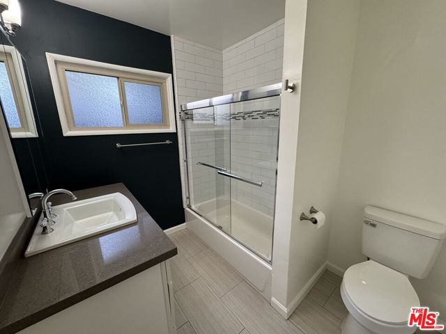 a bathroom with a sink a toilet a mirror and vanity