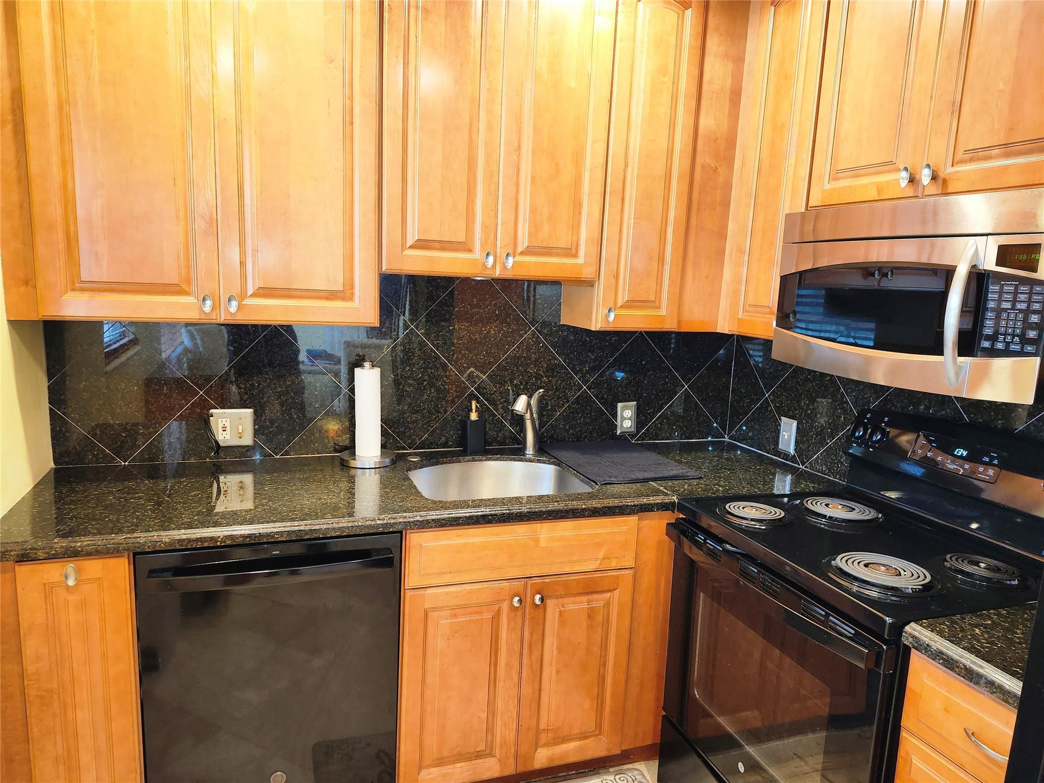 74 Preston Way Boca Raton, FL 33434 - Photo 8 of 28 a kitchen with stainless steel appliances granite countertop a stove a sink and a microwave