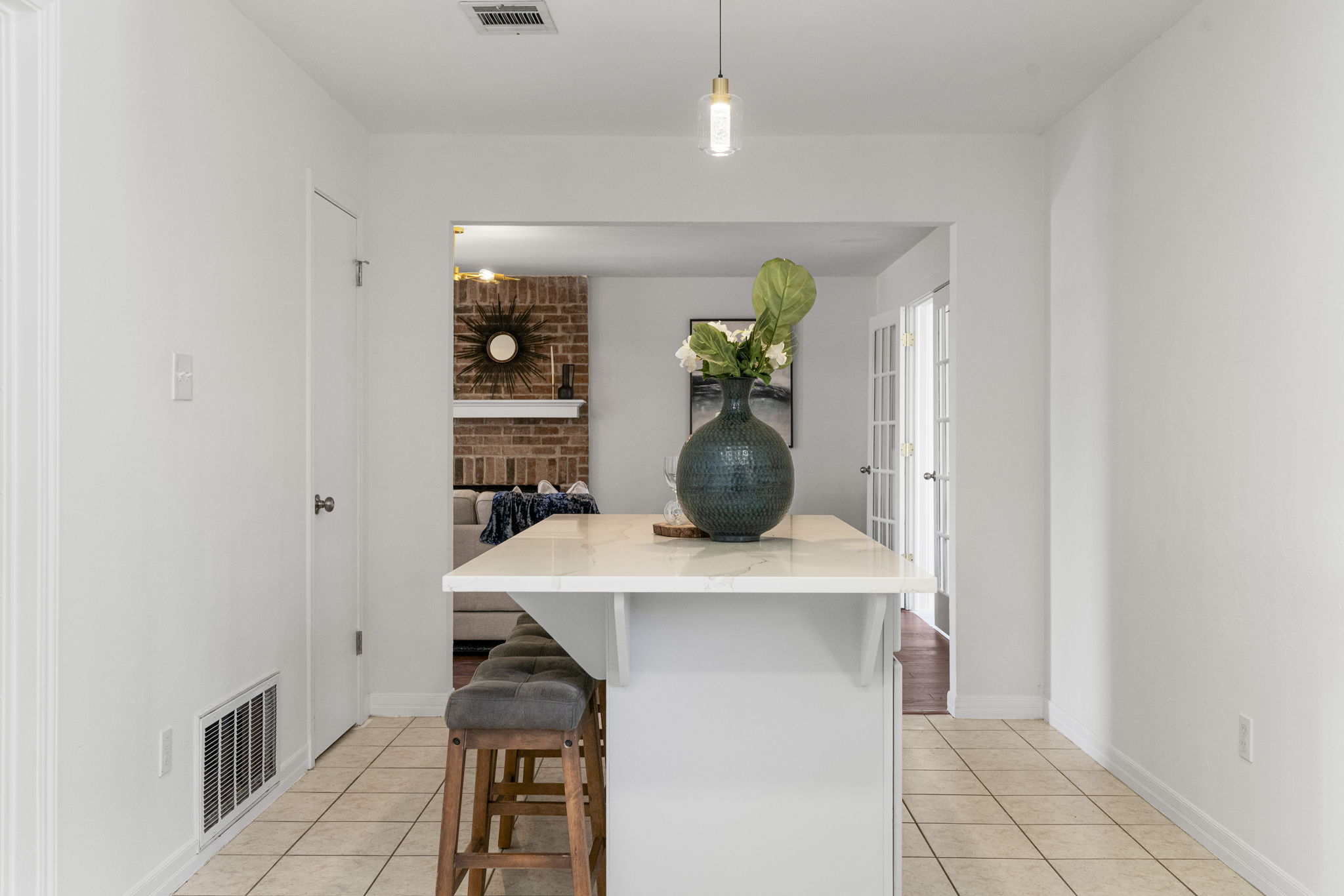13004 Esplanade Street Austin, TX 78727 - Photo 25 of 36 Kitchen with light tile patterned floors, a breakfast bar area, a center island, and light stone countertops