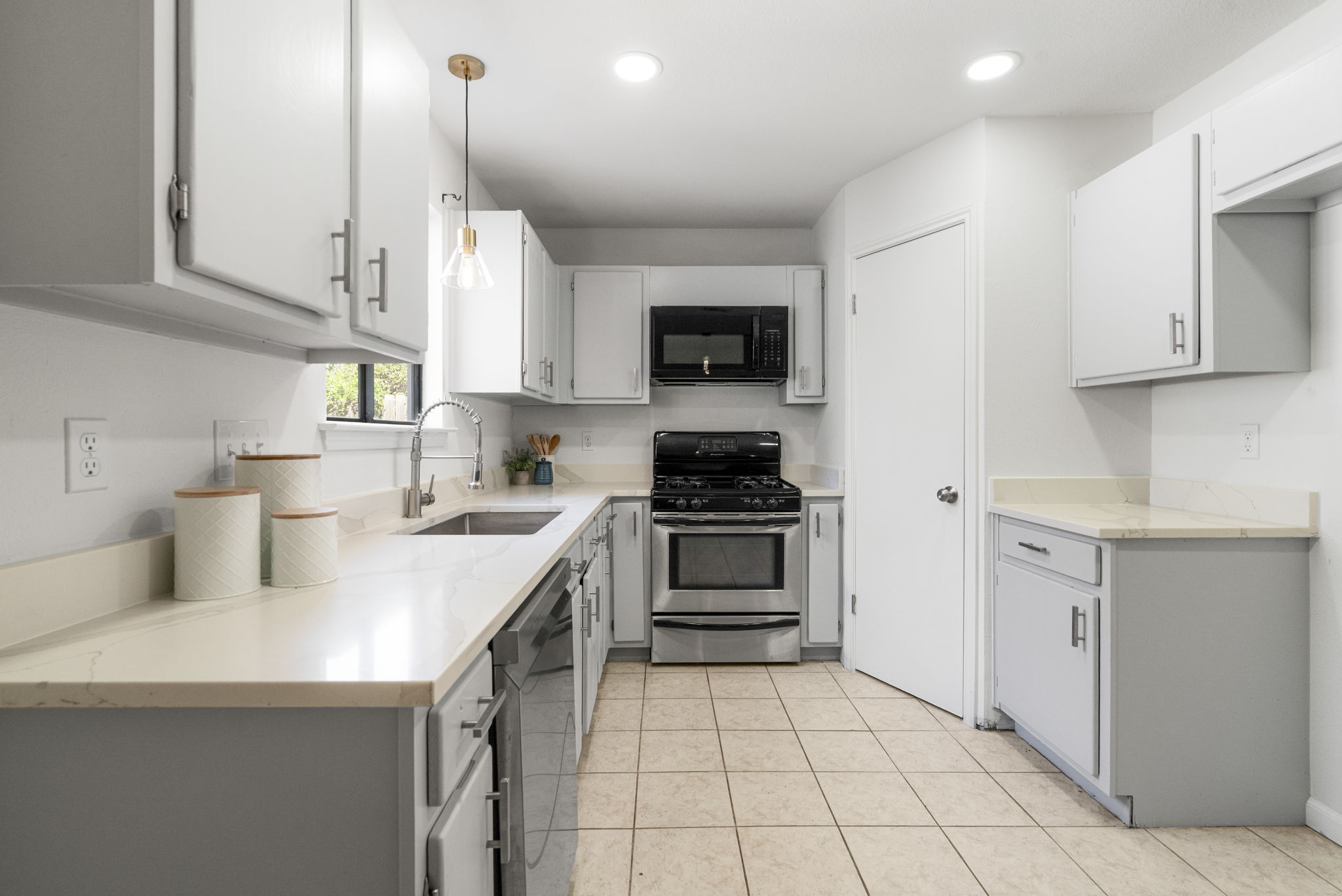 13004 Esplanade Street Austin, TX 78727 - Photo 5 of 36 Kitchen featuring stainless steel appliances, light stone counters, pendant lighting, and gray cabinetry