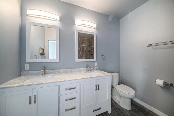 a bathroom with a granite countertop toilet sink and mirror