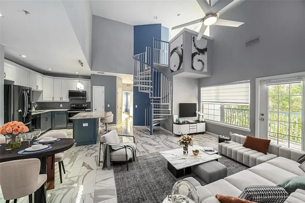 a living room with furniture kitchen view and a window