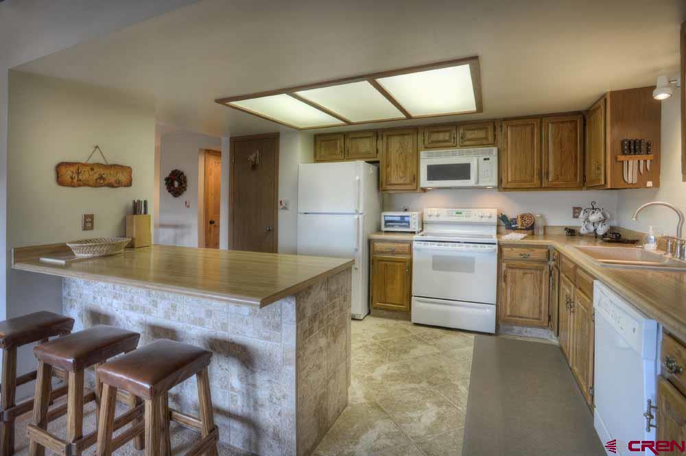 322 Sheol Street, Unit 7 Durango, CO 81301 - Photo 13 of 35 a kitchen with a sink a stove and chairs