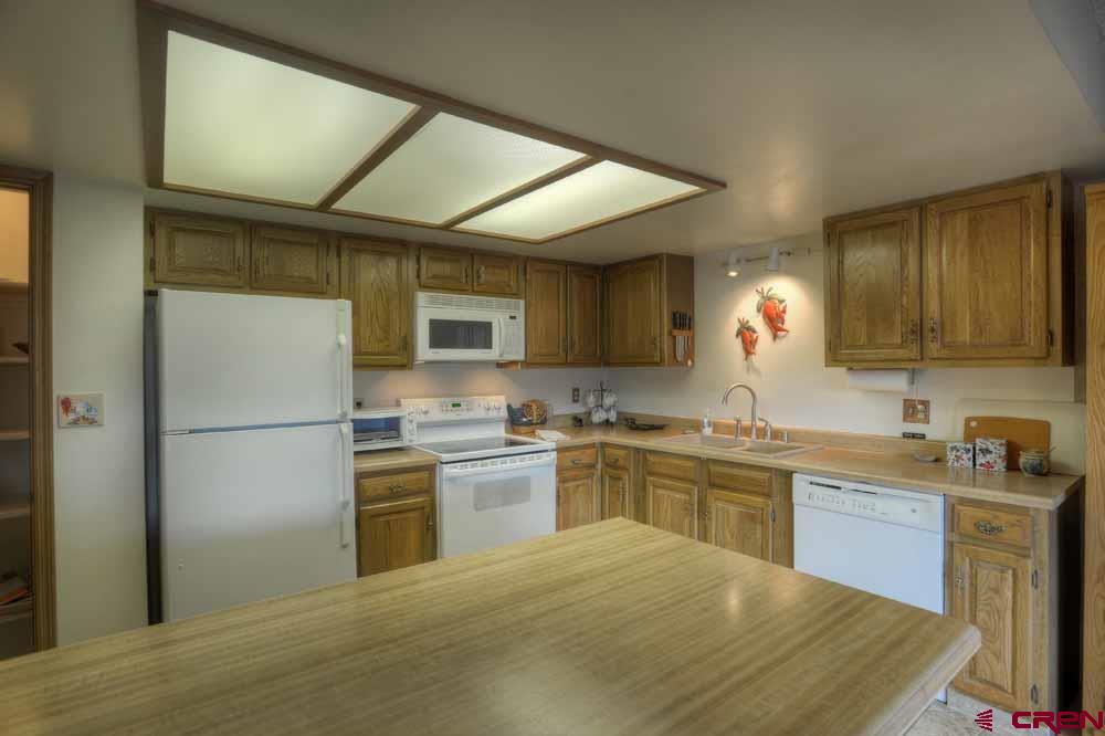 322 Sheol Street, Unit 7 Durango, CO 81301 - Photo 15 of 35 a kitchen with a sink a refrigerator and cabinets