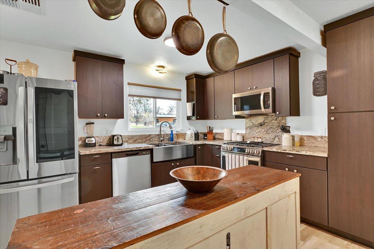 203 Tennessee Lane Bangor, CA 95901 - Photo 12 of 54 a kitchen with stainless steel appliances granite countertop a sink a stove top oven a refrigerator and dishwasher