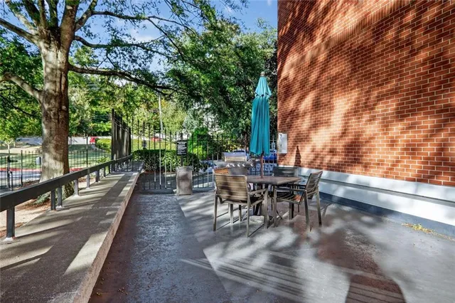 a view of a patio with table and chairs and floor to ceiling window