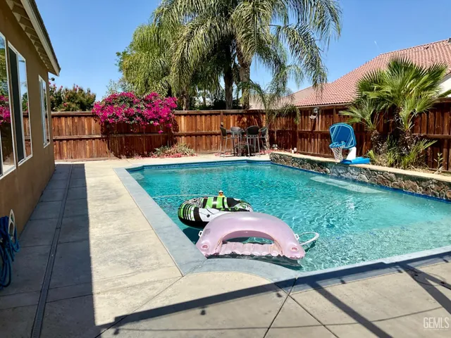 a backyard of a house with barbeque oven table and chairs