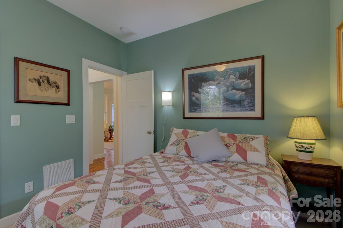 751 Everett Road Pisgah Forest, NC 28768 - Photo 16 of 36 a bedroom with a bed and a lamp on dresser