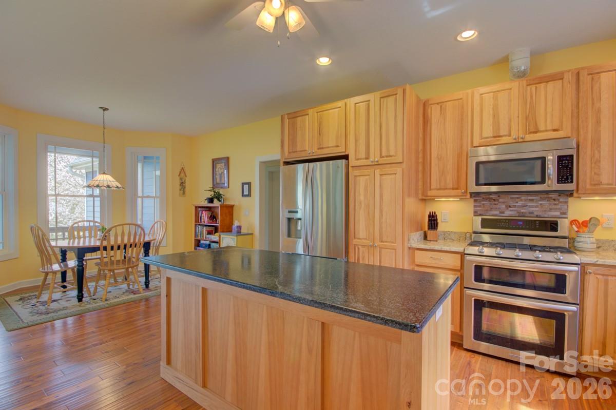 751 Everett Road Pisgah Forest, NC 28768 - Photo 18 of 36 a kitchen with stainless steel appliances granite countertop a refrigerator a stove top oven a sink and dishwasher