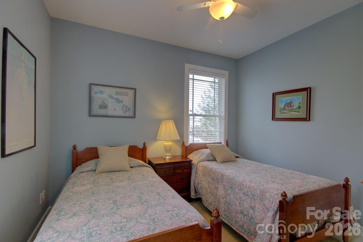751 Everett Road Pisgah Forest, NC 28768 - Photo 30 of 36 a bedroom with two beds and a chandelier