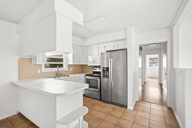 a kitchen with a white cabinets and white appliances