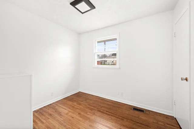 a view of room with wooden floor and ceiling fan