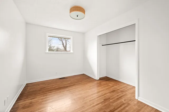 a view of a big room with wooden floor and a ceiling fan