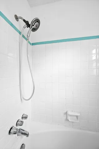 a view of washer and dryer with bathroom in the background