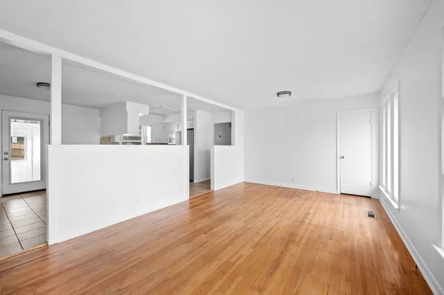 a view of a kitchen with wooden floor and a sink