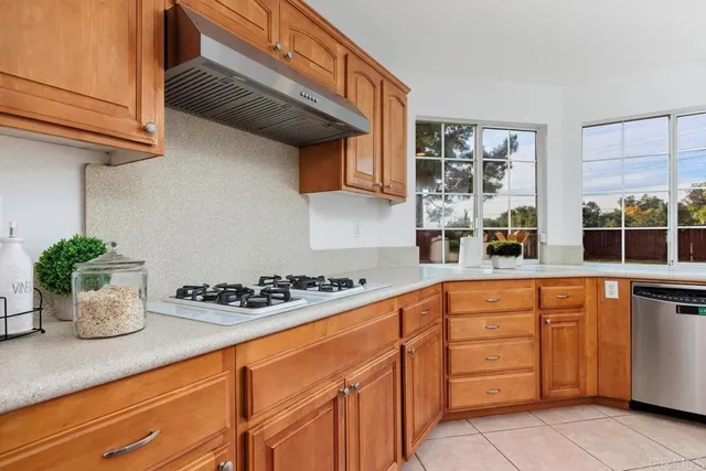 a kitchen with stainless steel appliances granite countertop a sink a stove and cabinets
