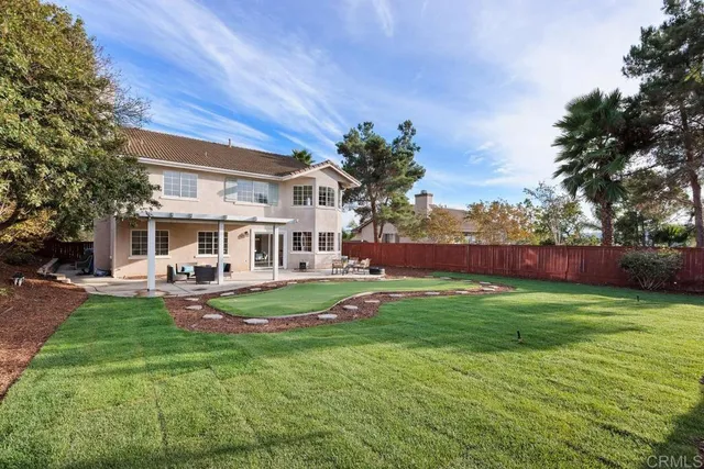 a front view of a house with garden and trees