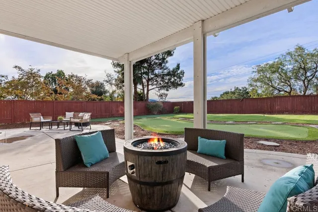 a view of a patio with couches chairs and a yard