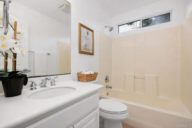 a bathroom with a granite countertop sink toilet and a mirror