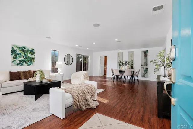 a living room with furniture and wooden floor