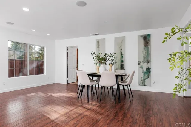 a dining room with furniture potted plants and wooden floor