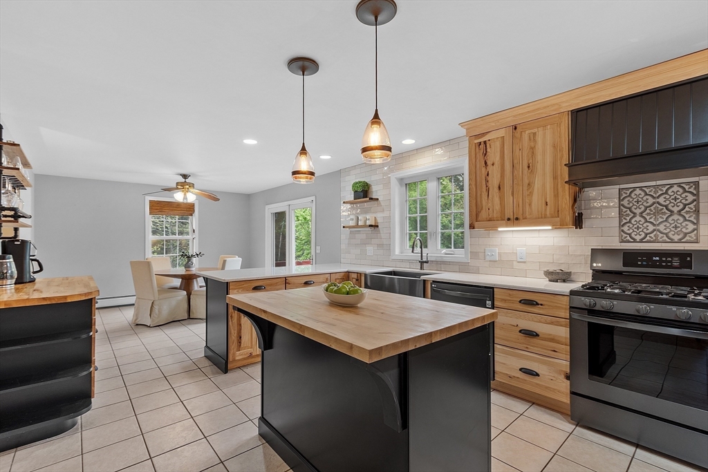 30 Page Epping, NH 03042 - Photo 8 of 42 a kitchen with a stove a sink a dining table and chairs
