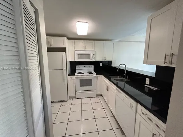 a kitchen with a sink a refrigerator and cabinets