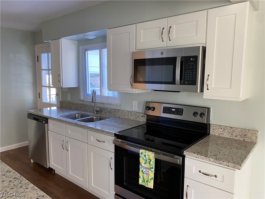 1147 Richmond Road Cleveland, OH 44124 - Photo 9 of 28 Kitchen featuring appliances with stainless steel finishes, dark hardwood / wood-style floors, white cabinets, and sink