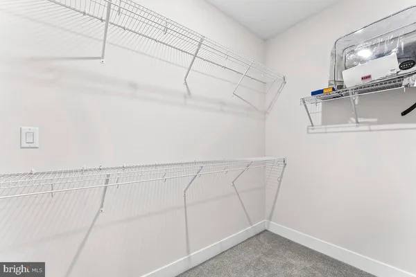 a bedroom with a bed a mirror on dresser and a flat screen tv