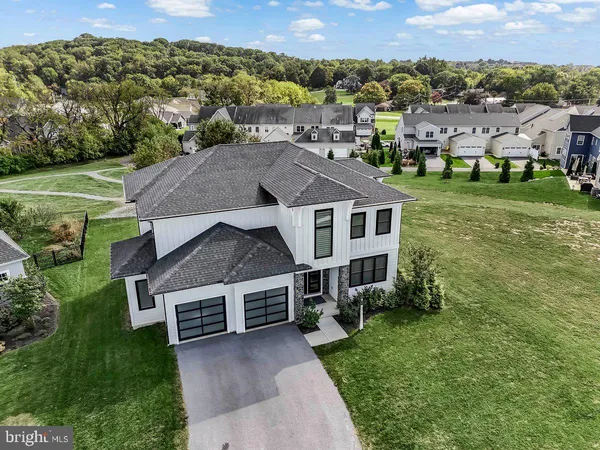 an aerial view of residential houses with outdoor space and trees
