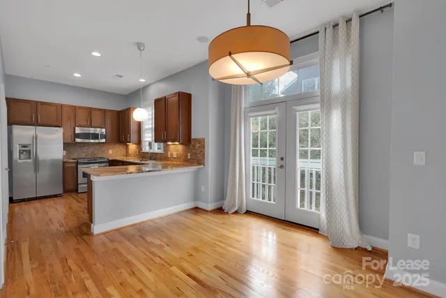 a kitchen with stainless steel appliances granite countertop a refrigerator and a stove top oven