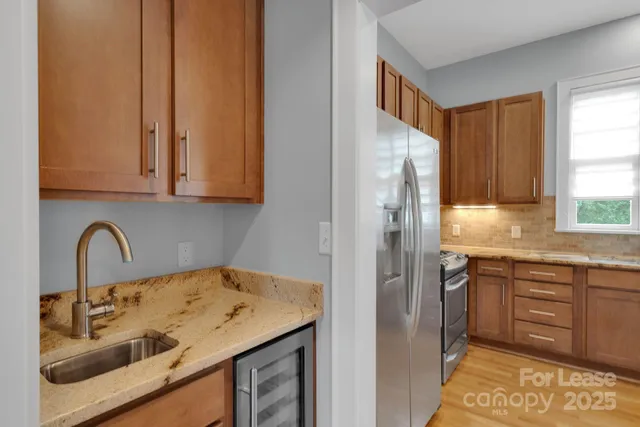 a kitchen with a sink a refrigerator and window