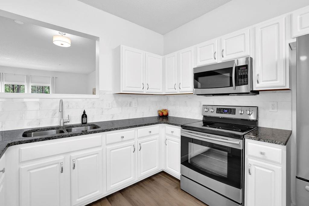 215 Riverstone Commons Circle Canton, GA 30114 - Photo 20 of 36 a kitchen with granite countertop white cabinets white stainless steel appliances and a sink