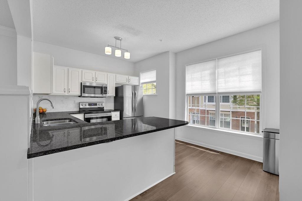 215 Riverstone Commons Circle Canton, GA 30114 - Photo 22 of 36 a kitchen with granite countertop a stove a sink and a refrigerator