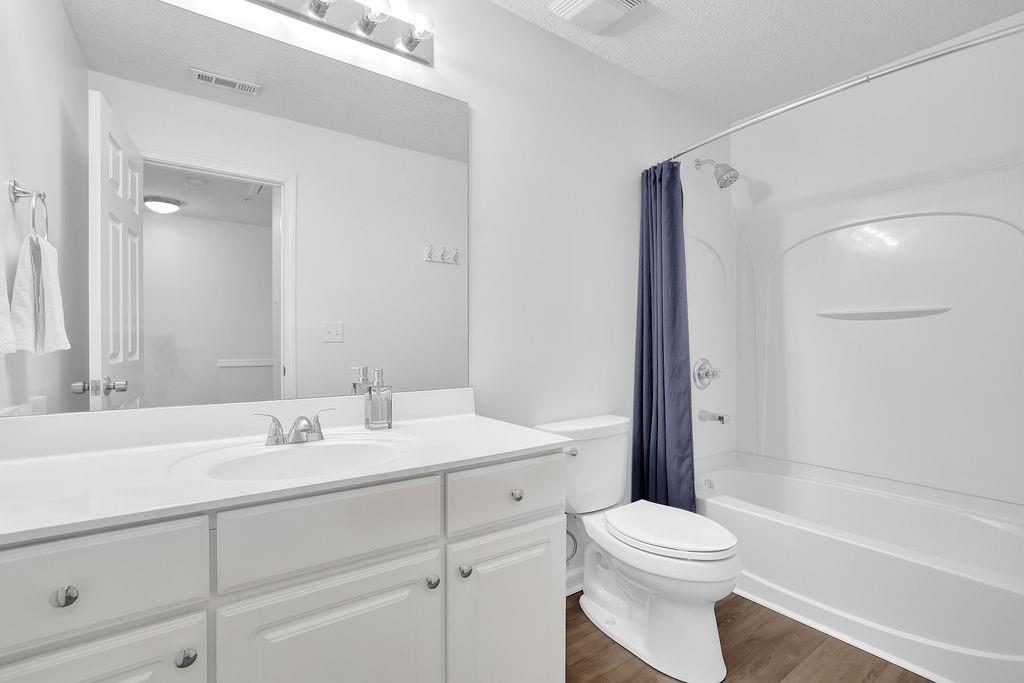 215 Riverstone Commons Circle Canton, GA 30114 - Photo 25 of 36 a bathroom with a toilet a sink a mirror a bathtub and vanity