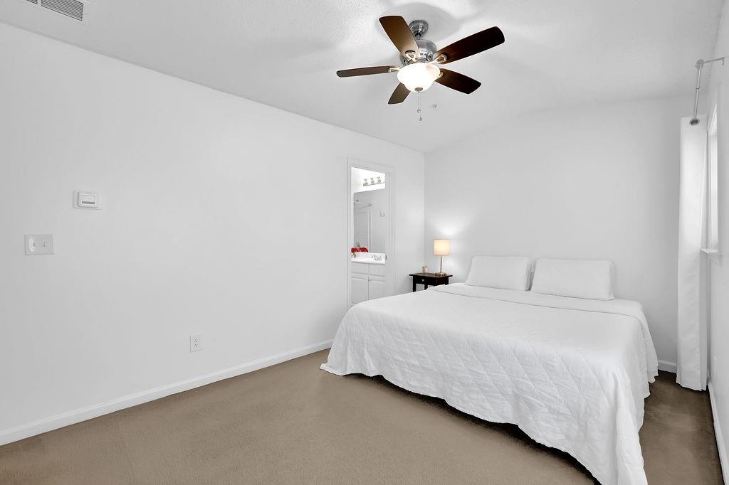 215 Riverstone Commons Circle Canton, GA 30114 - Photo 30 of 36 a bedroom with a large bed and a chandelier