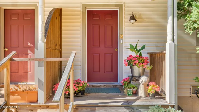 a vase with flowers sitting on a table in front of a door