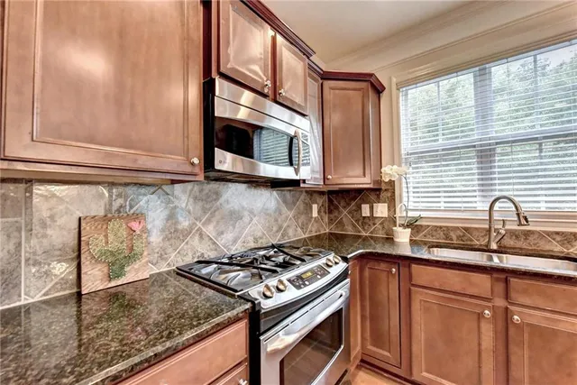 a kitchen with stainless steel appliances granite countertop a sink stove and microwave