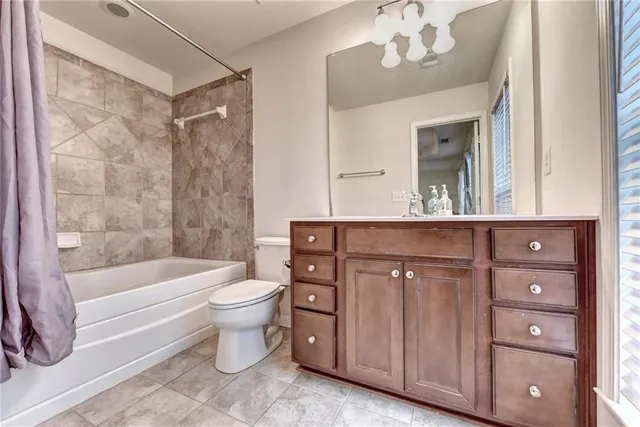 a bathroom with a bathtub shower sink mirror and toilet